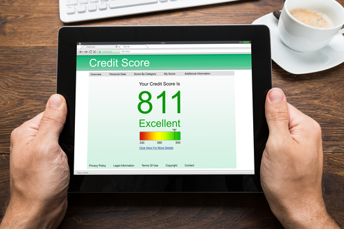 Person Hands With Digital Tablet Showing Credit Score